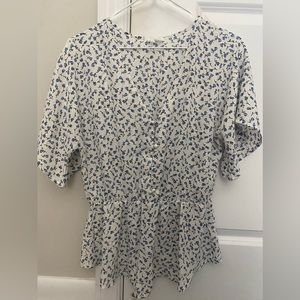 Short sleeve v neck blouse with buttons down front and an elastic cinch at waist